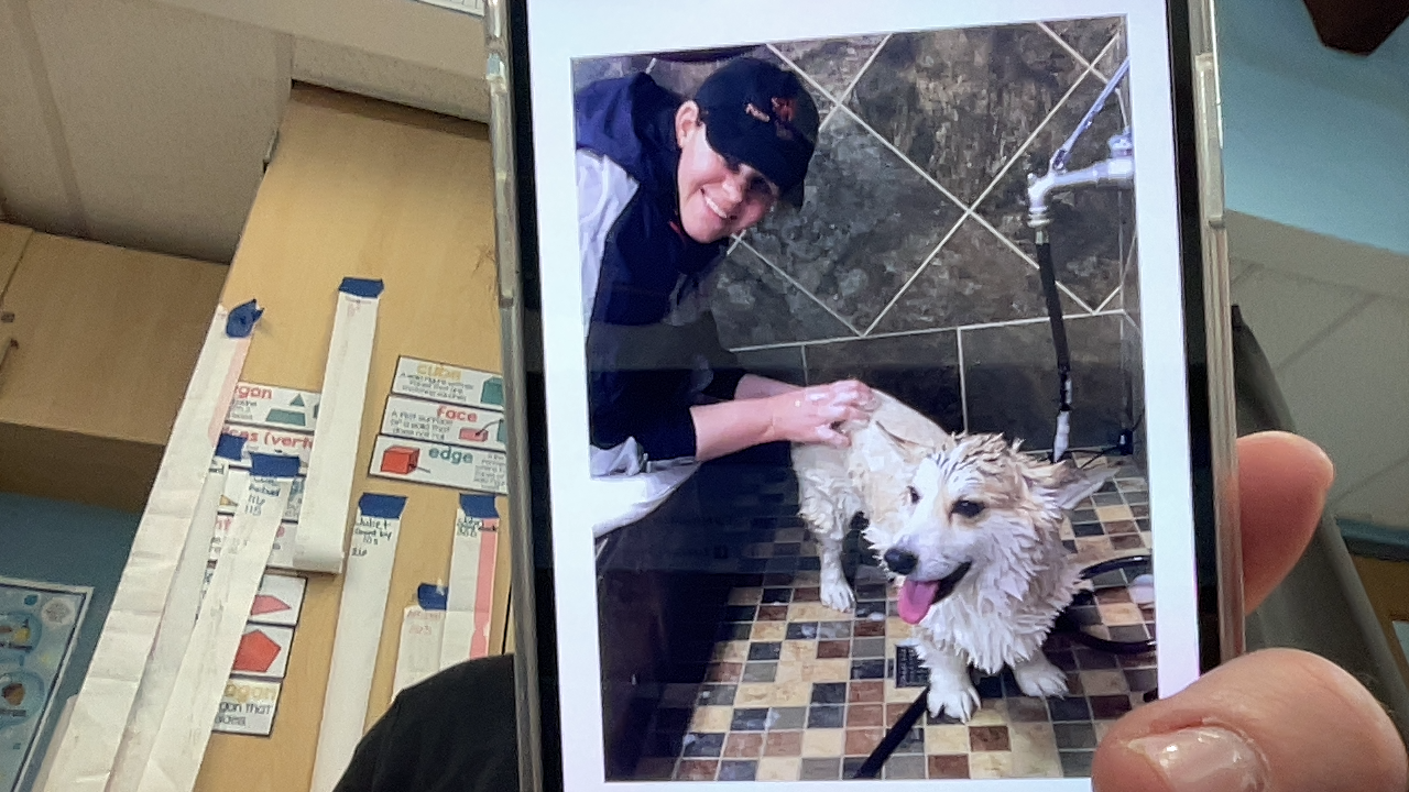 Adria Michelman smiling while bathing a dog