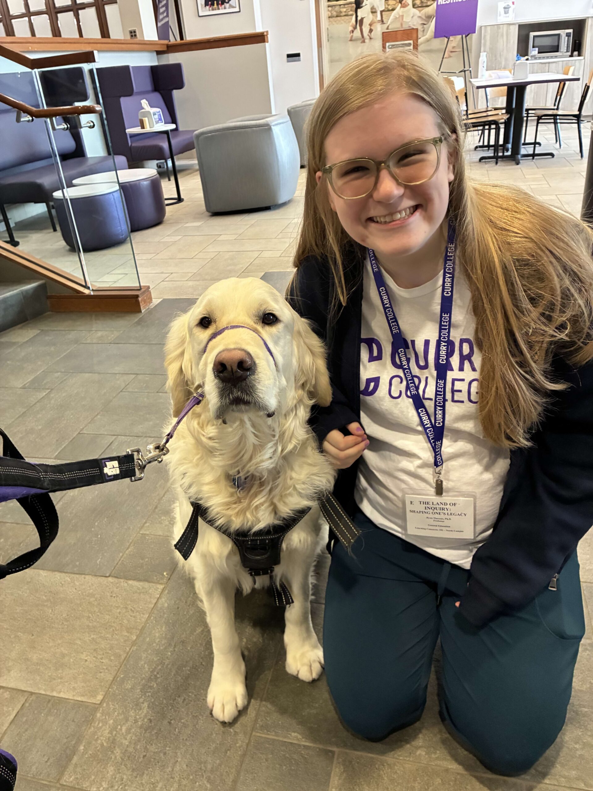 Charlotte Stafford smiling beside a golden retriever