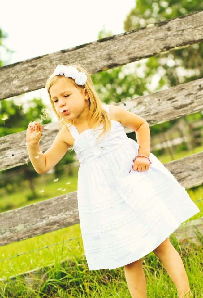 Hayden Anderton as a child blowing dandelion seeds