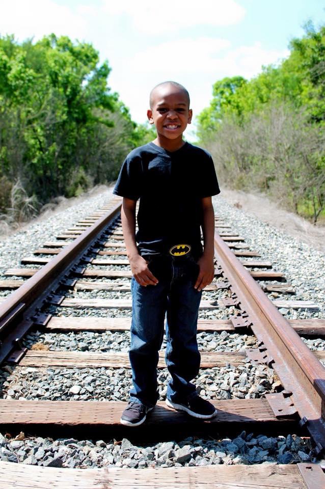 Isaiah Stringfield smiling outdoors as a child