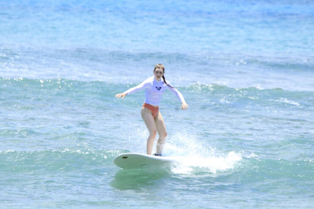 Alexi Rittger surfing on a bright ocean wave
