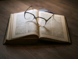 A pair of eyeglasses resting on the pages of an open book