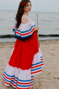 Helaina Taylor holding her flute beside the water.