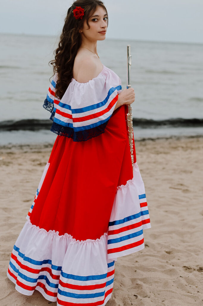 Helaina Taylor holding her flute beside the water.