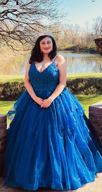 Olivia Long in a blue dress beside a pond.