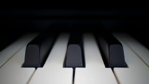 A close-up of black and white piano keys, a stock photograph representing practice and persistence.