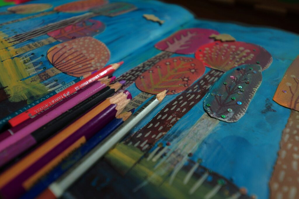 Colored pencils on colorful artwork. Stock photograph; the artwork is not the applicant’s work.