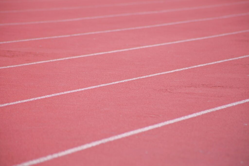 White lane markings on a running track, a stock photograph representing persistence.