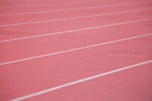 White lane markings on a running track, a stock photograph representing persistence.